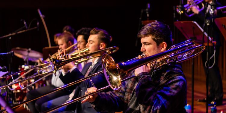Big Band students on stage performing with trombones