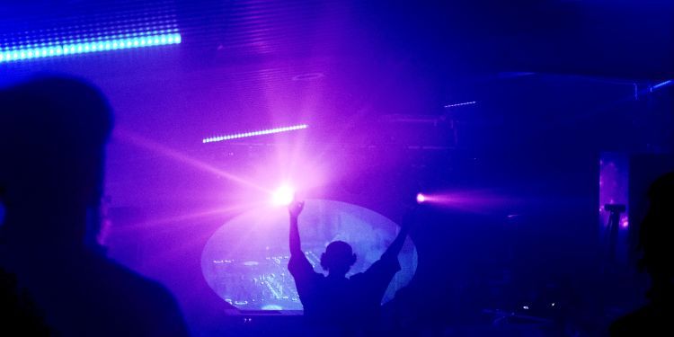 A night club with a DJ at a sound desk 
