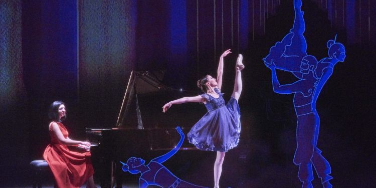 Pianist and ballerina performing next to an animation of the Nutcracker
