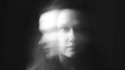 Blurred, ghost-like figure on a black background