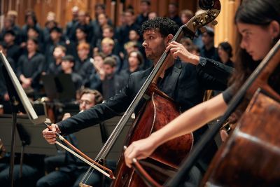 Double bassists in front of choir